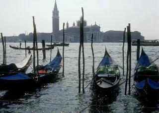 Blick auf Venedig mit Gondeln im Wasser und historischen Gebäuden im Hintergrund.