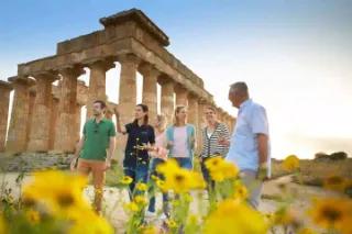 Eine Gruppe von Touristen, die vor antiken Säulen stehen und sich unterhalten.