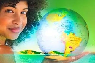 Eine Frau hält eine Weltkugel mit einer grünen Landschaft im Hintergrund.