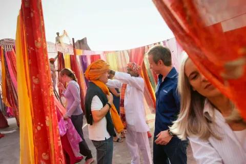 Eine lebendige Markt-Szene in Indien mit bunten Stoffen und Menschen.