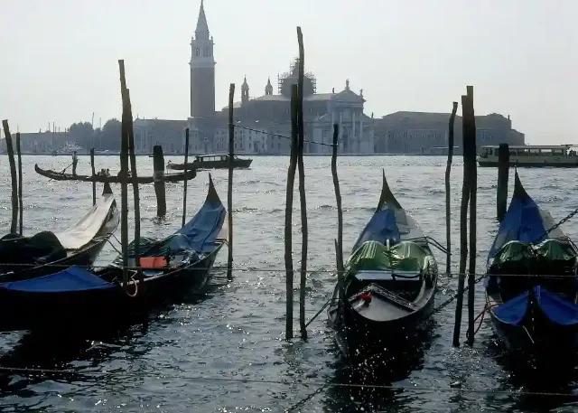 Blick auf Venedig mit Gondeln im Wasser und historischen Gebäuden im Hintergrund.
