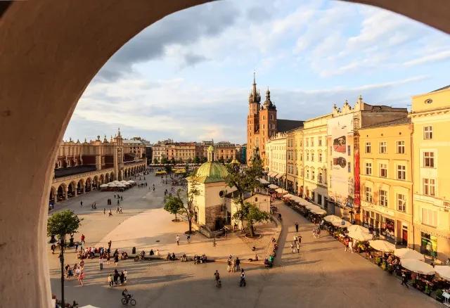 Blick auf den Marktplatz in Krakau mit historischen Gebäuden und Menschen.