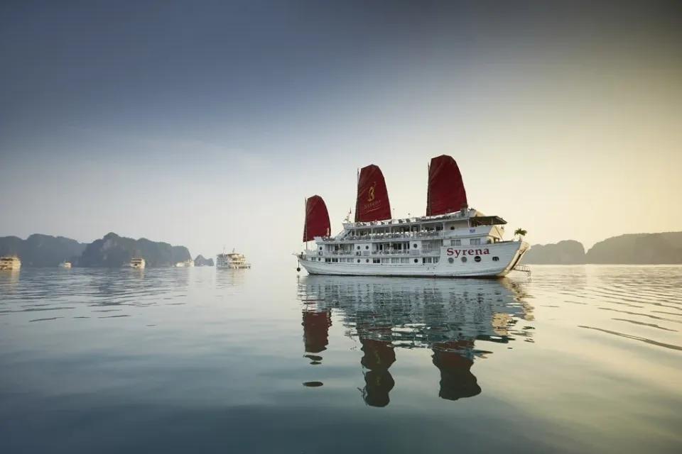 Ein Traditionelles Segelschiff mit roten Segeln in der Halong-Bucht in Vietnam.